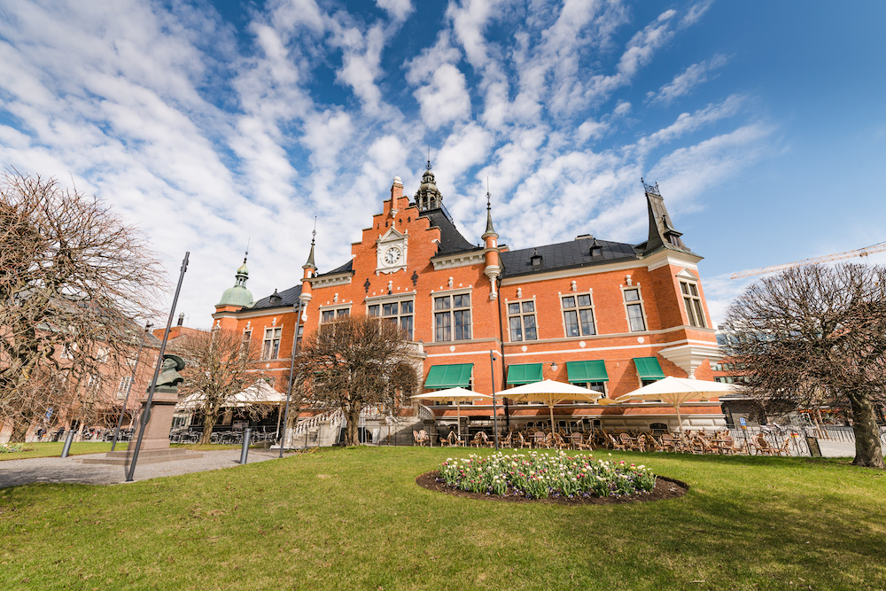 Umeå Town Hall, the main facade facing south, the side view photo from the right side. The spring time, sunny day with blue skies, trees have no leaves yet