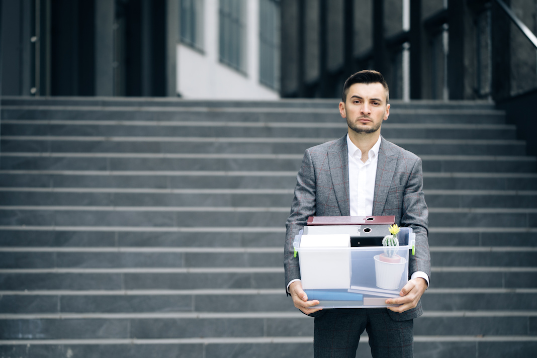 Businessman gets fired and walking near office center with box documents. Lost His Job. Unemployment rate growing due pandemic. Male office worker in despair lost job